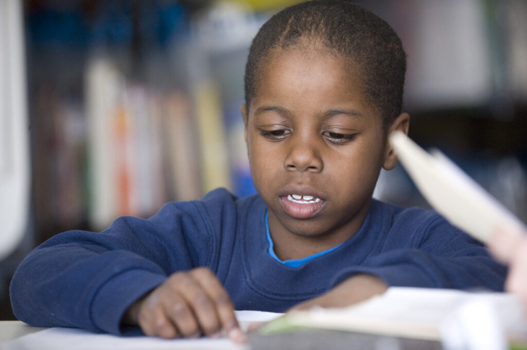 little boy reading in Reading Corps